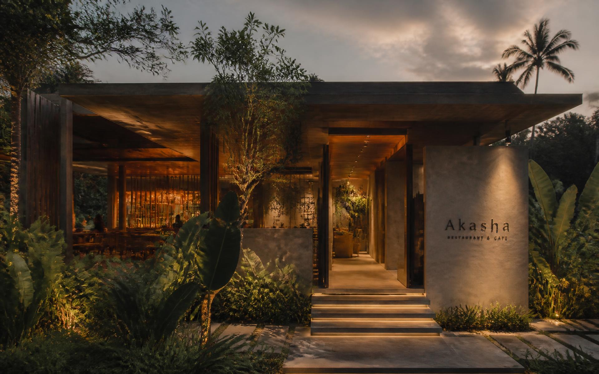 The lantern-lit entrance of Locavore NXT at dusk, framed by jungle planting